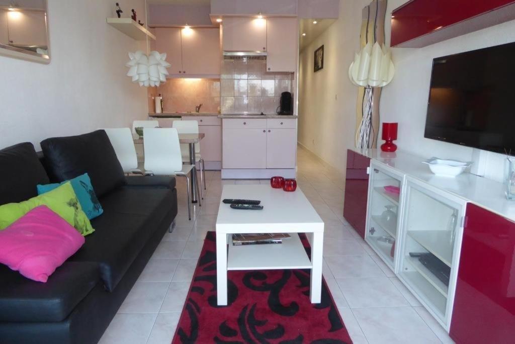 - un salon avec un canapé noir et une table blanche dans l'établissement Cap Agde Village naturiste Port Nature, au Cap d'Agde