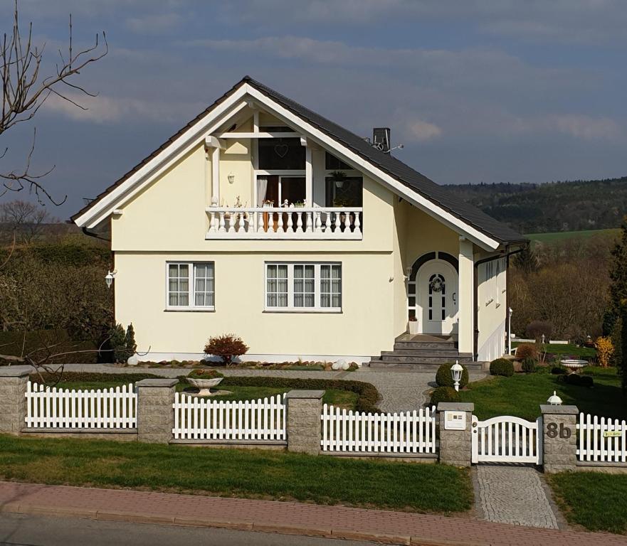 ein weißes Haus mit einem weißen Gartenzaun in der Unterkunft Ihre Auszeit am Golfplatz in Meisdorf