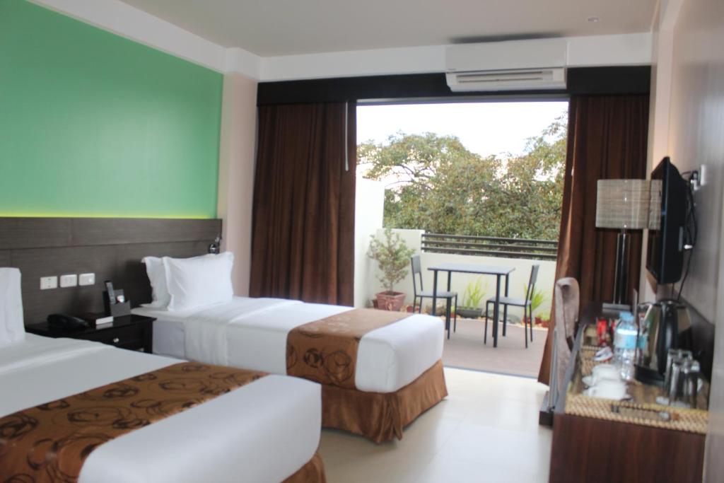 Postel nebo postele na pokoji v ubytování Kew Hotel Tagbilaran