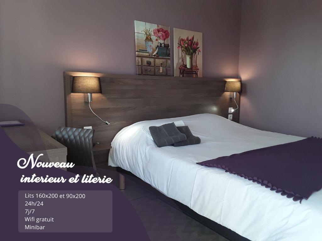 a bedroom with a large bed with a wooden headboard at Relais Motel de Maisonnay in Maisonnay