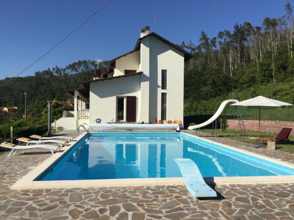 a villa with a swimming pool in front of a house at Villa Mara in Riccò del Golfo di Spezia