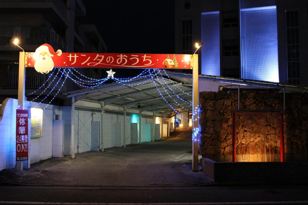 Una señal para un edificio con luces de Navidad. en Santa no Ouchi-LoveHotel, en Miyazaki