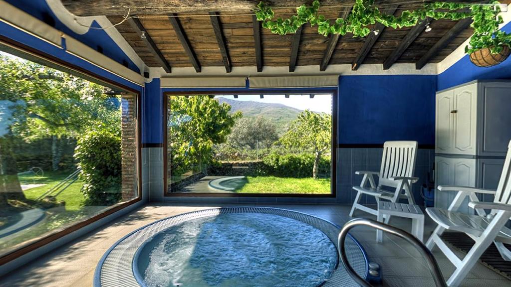 a hot tub in a patio with a table and chairs at El Canchal de la Gallina -Cafetería -Aparcamiento gratis - Jacuzzi in Hervás