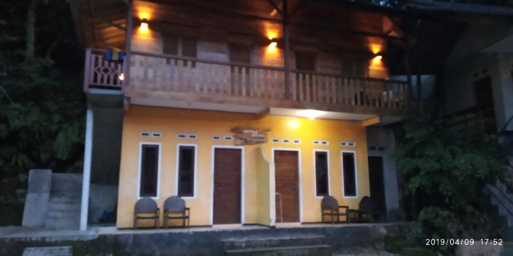 un bâtiment avec un balcon en haut le soir dans l'établissement NAYYLA Homestay, à Pangandaran