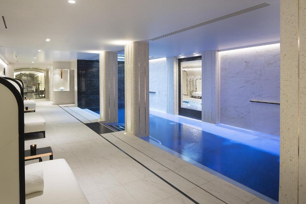 a swimming pool in a house with blue walls at Le Narcisse Blanc in Paris
