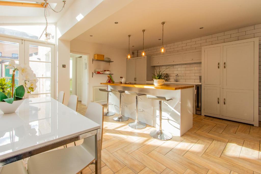 a kitchen with white cabinets and a island with bar stools at 39 Hamilton Street in Cardiff