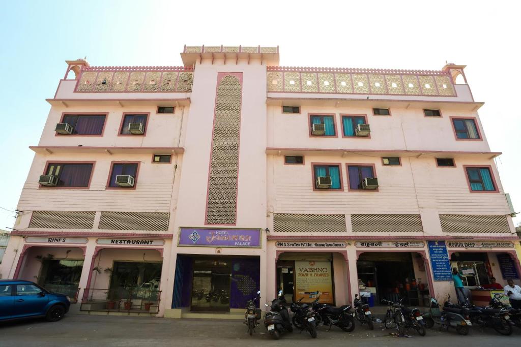 un gran edificio rosa con motos estacionadas frente a él en Hotel Jaisingh Palace, en Jaipur