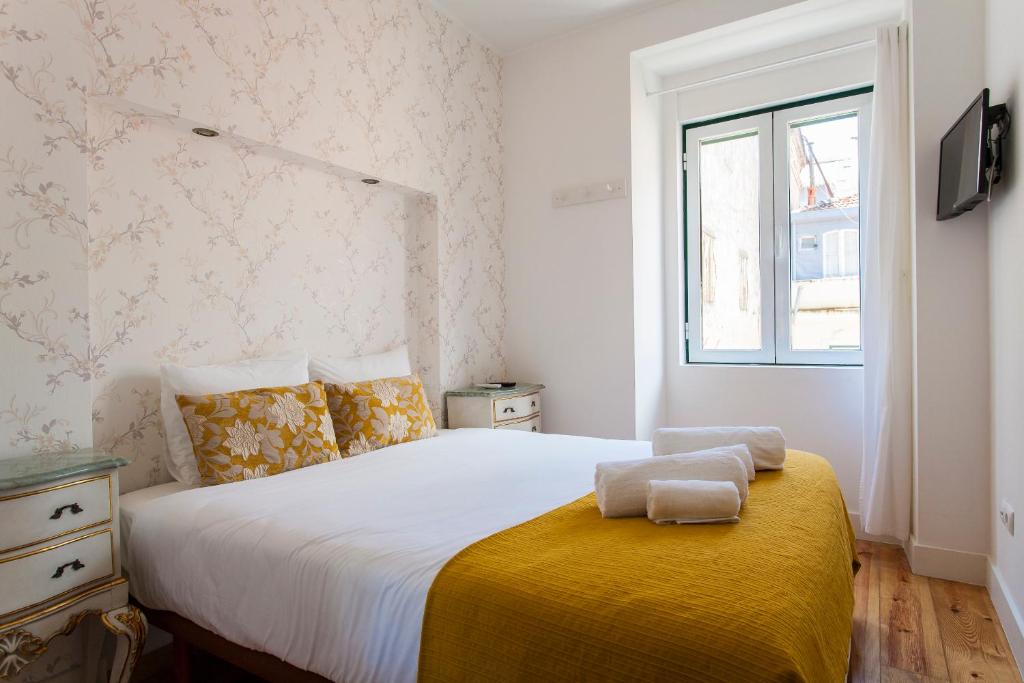 um quarto com uma cama com duas toalhas em CARDAL em Lisboa
