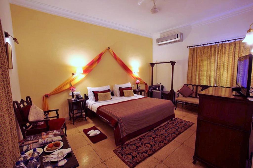 a bedroom with a bed and a couch in a room at Hotel Rawalkot Jaisalmer in Jaisalmer