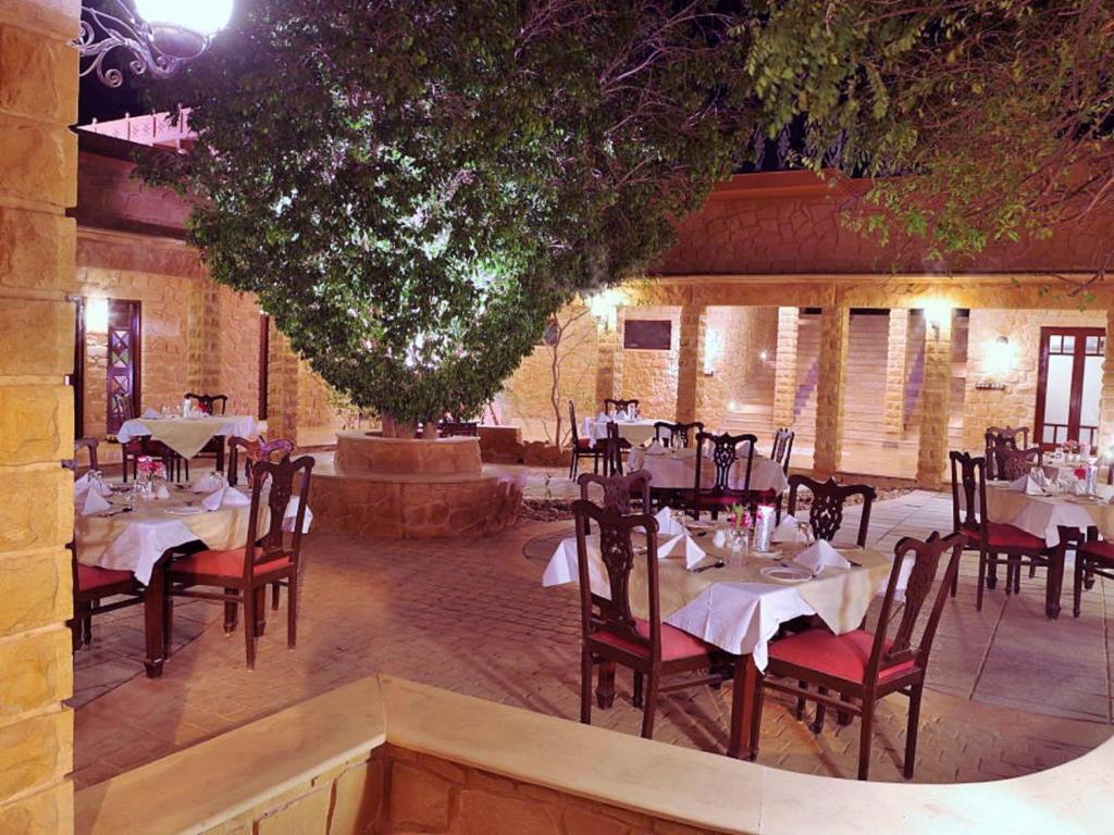 a restaurant with tables and chairs in a room at Hotel Rawalkot Jaisalmer in Jaisalmer