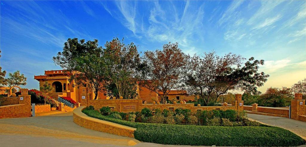a garden with bushes and trees and a building at Hotel Rawalkot Jaisalmer in Jaisalmer