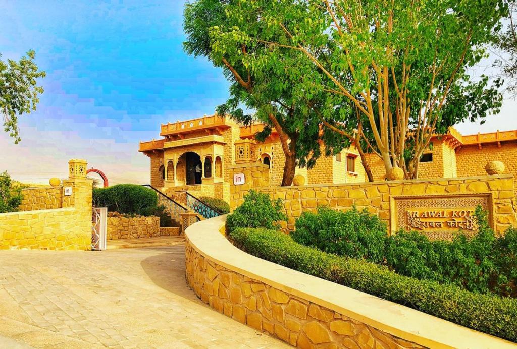 un edificio con una valla de piedra y una pared de piedra en Hotel Rawalkot Jaisalmer en Jaisalmer