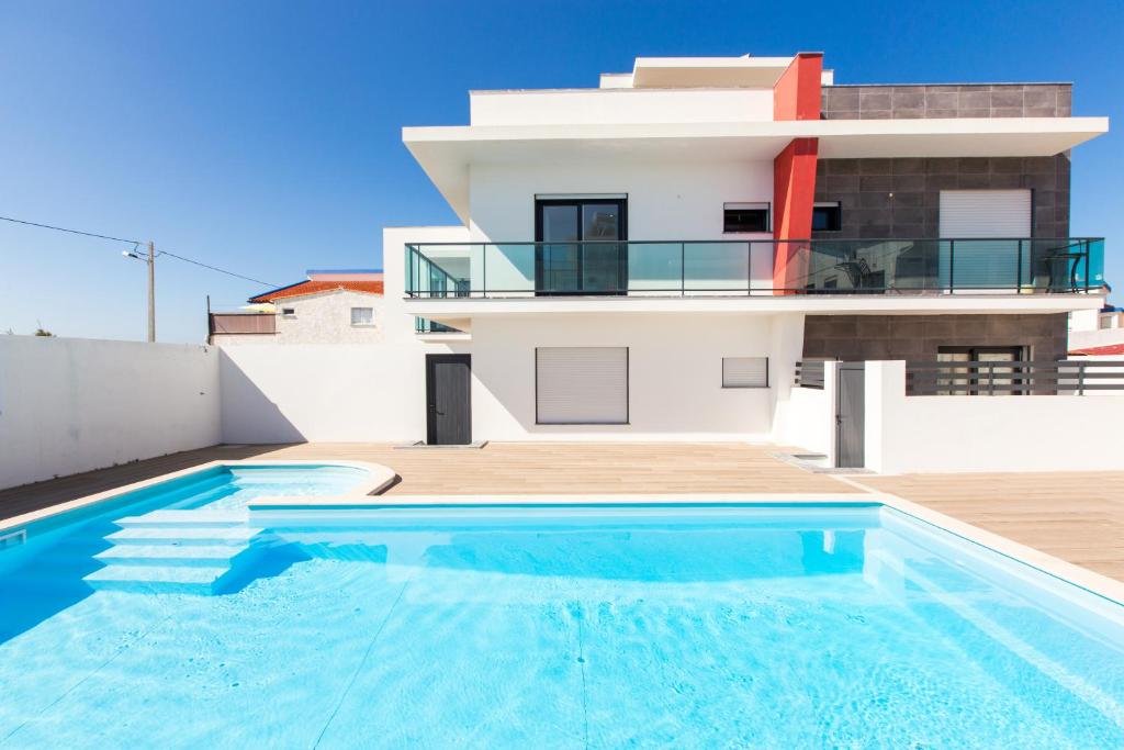 a house with a swimming pool in front of a house at Vitamin Sea, The Sea View Apartment in Baleal