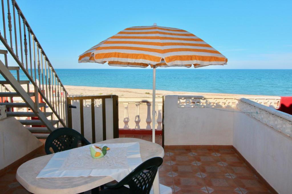 デニアにあるAlmadrava Playa Apartamentoのビーチ用の傘付きテーブル