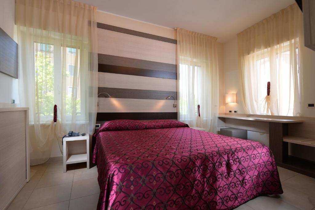 Postel nebo postele na pokoji v ubytování Hotel Siena