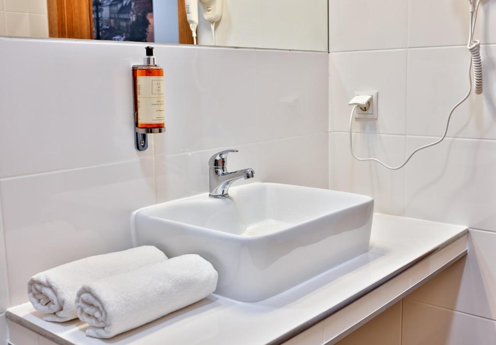 biała umywalka z ręcznikami na ladzie w obiekcie HOTEL LUBLIN w mieście Lublin
