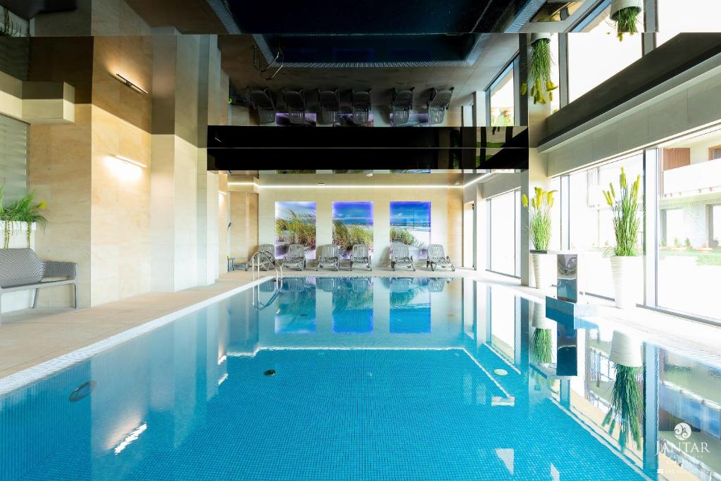 a large swimming pool in a building at Jantar Apartamenty - Beach Resort in Kołobrzeg