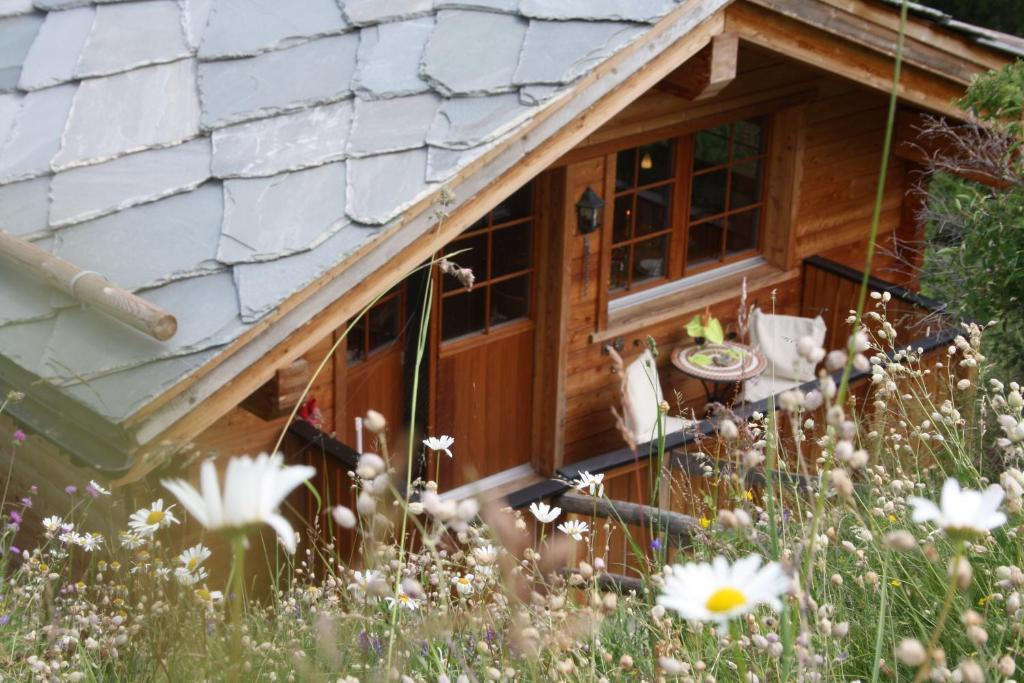 a cabin in a field of flowers at Chalet Hinter dem Rot Stei, private wellness, in ski and hiking area of Zermatt in Zermatt