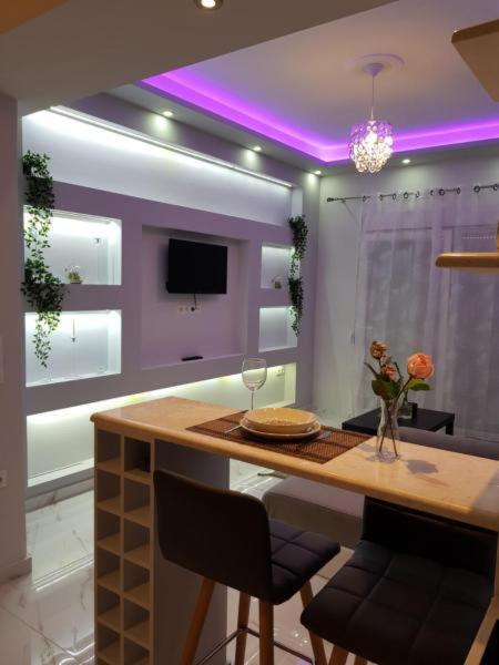 a kitchen with a table with chairs and a purple ceiling at kristina family home in Nea Iraklia