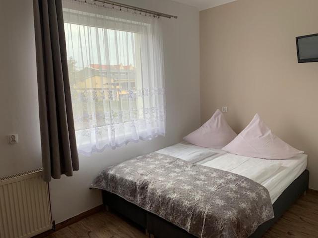 łóżko w pokoju z oknem i łóżko sidx sidx sidx w obiekcie Willa Solna w Kołobrzegu