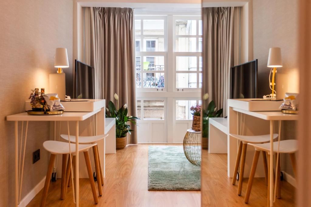 - un salon avec deux tables et une fenêtre dans l'établissement APARTAMENTOS FRANJA 55, à La Corogne