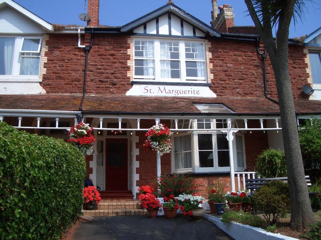 Uma casa de tijolos com um cartaz que diz St. Maryebone em St Marguerite em Paignton