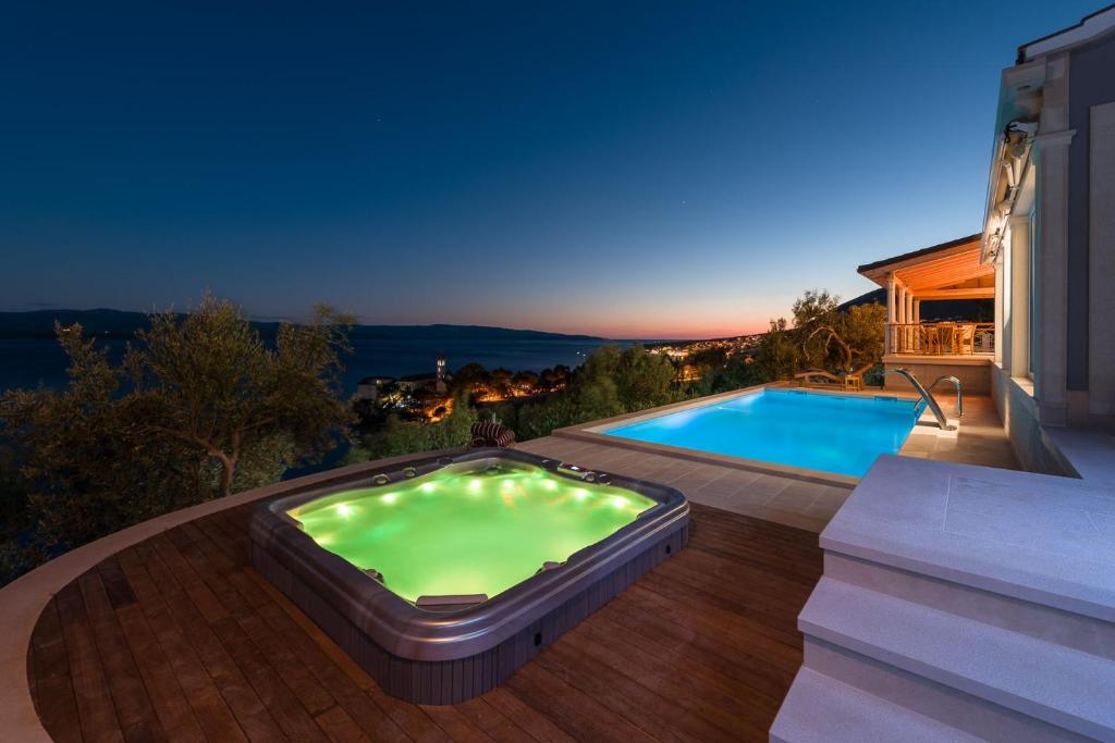 een zwembad op een terras naast een huis bij Villa Sapore di Sale with Pool in Bol