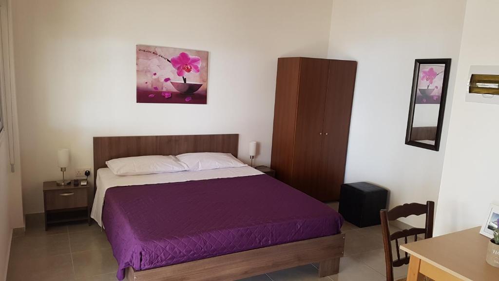 a bedroom with a bed with a purple blanket at ZORBAS Sea View No 1 - Antoniella in Larnaca