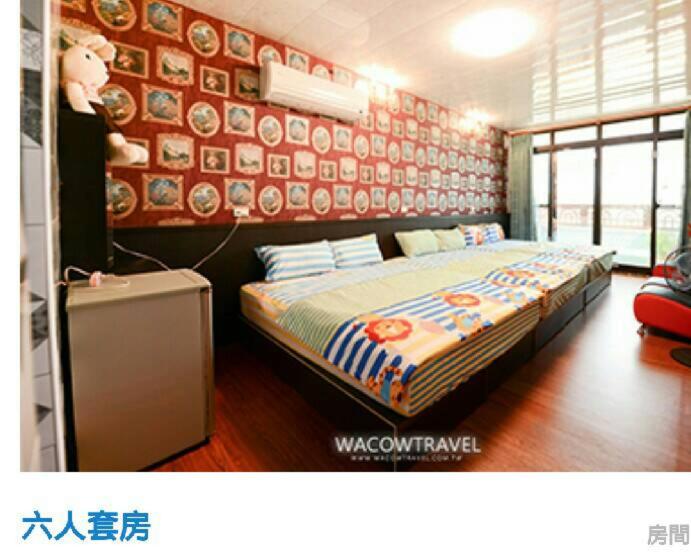 Un dormitorio con una cama y una pared con placas. en Full House B&B, en Xiaoliuqiu