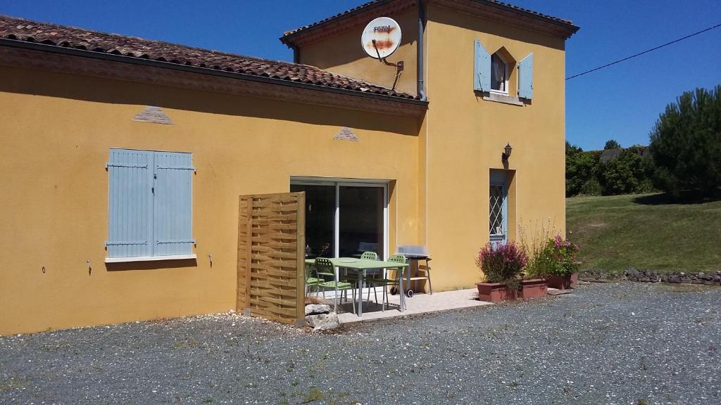 a yellow house with a table in front of it at LA MARVINIERE in Saint-Bonnet-sur-Gironde