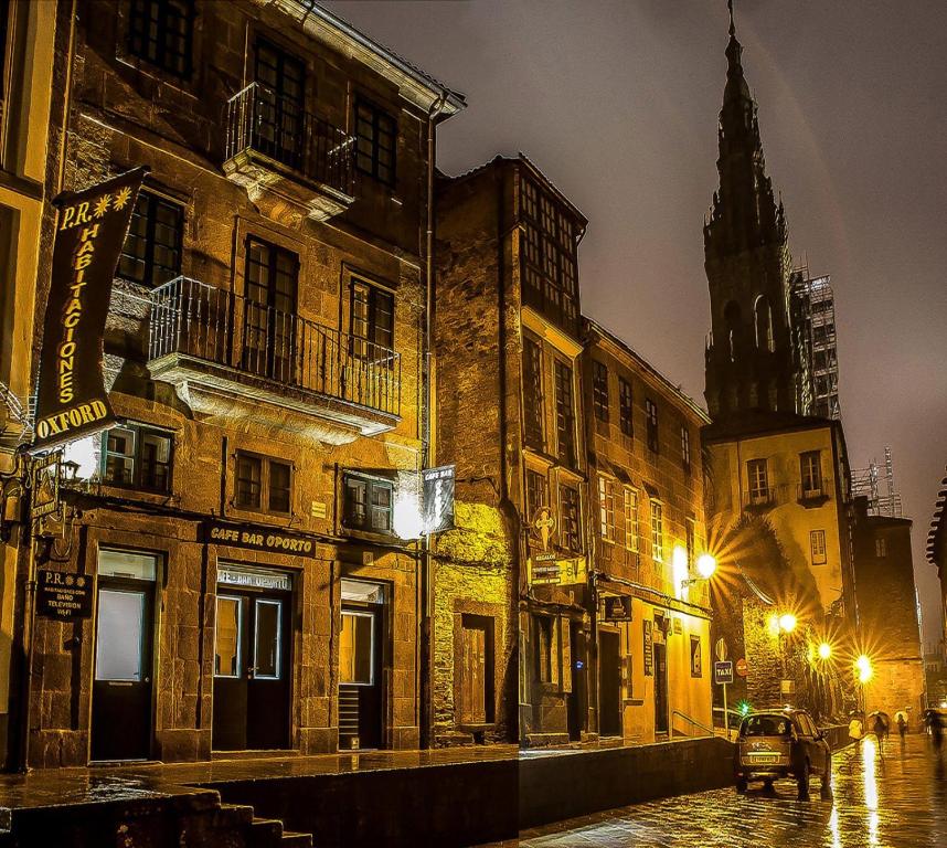 a city street at night with a church at Oxford Suites Santiago de Compostela in Santiago de Compostela