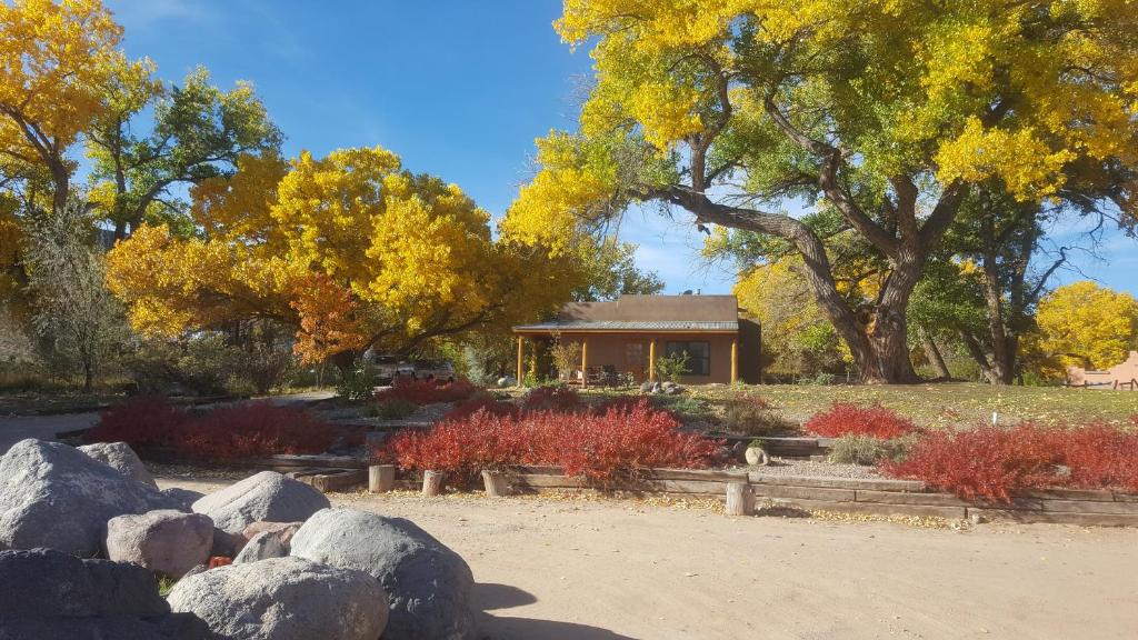 a garden with rocks and a house in the background at Abiquiu Inn in Abiquiu