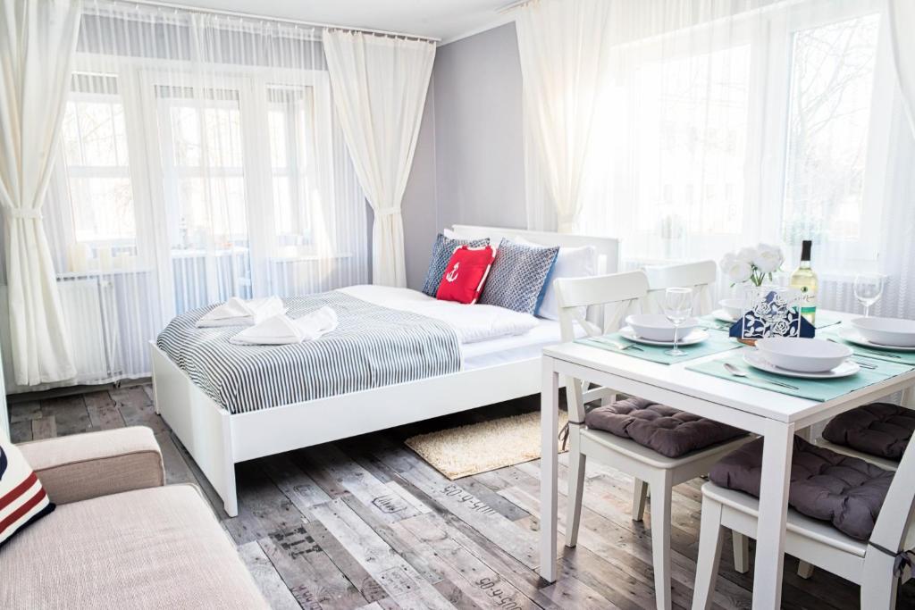 a living room with a white couch and a table at Morning Star Apartments in Międzyzdroje