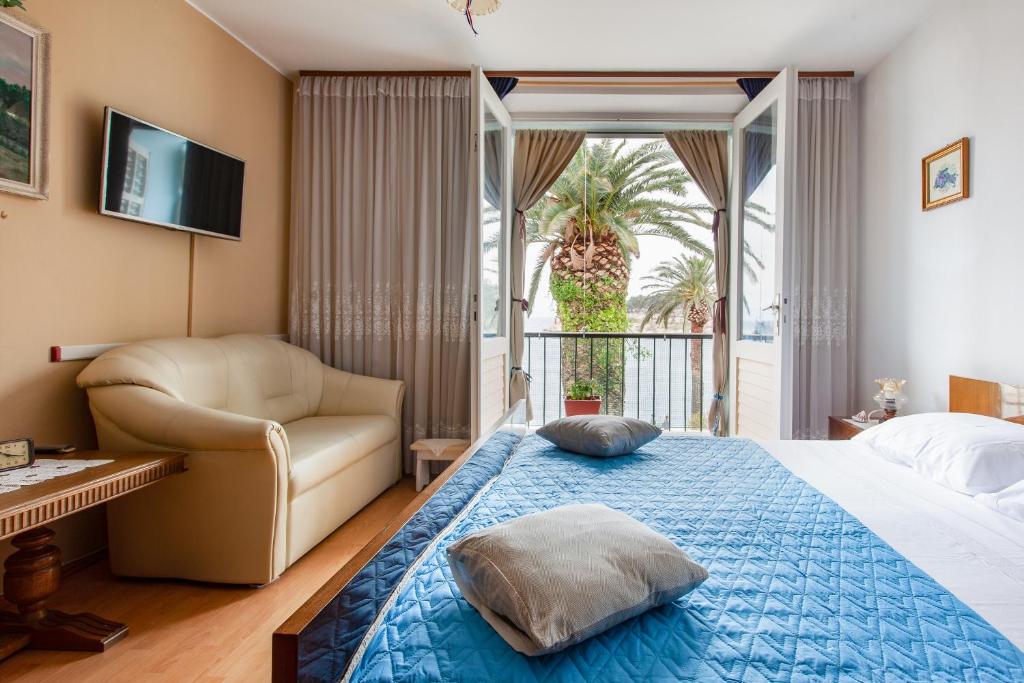 ein Schlafzimmer mit einem Bett, einem Stuhl und einem Fenster in der Unterkunft RUŽA in Makarska