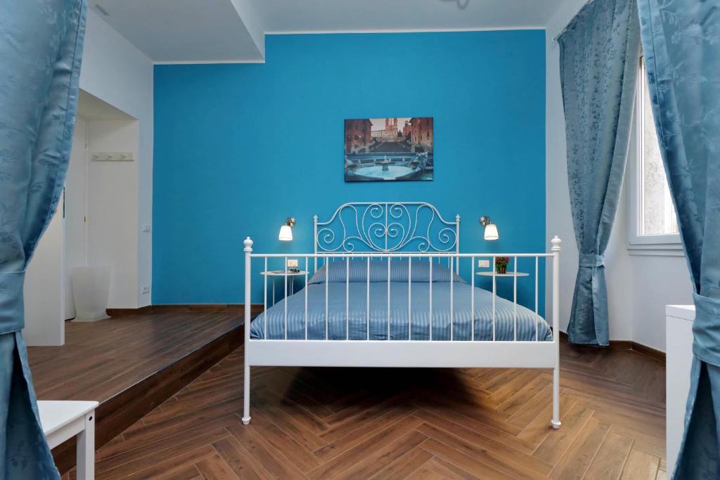 a blue bedroom with a white bed and a blue wall at Domus Ponte Milvio in Rome