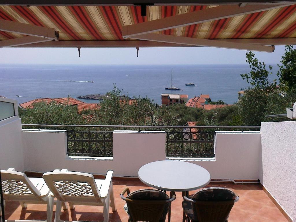 a balcony with tables and chairs and a view of the ocean at Oaza Guest House in Sveti Stefan