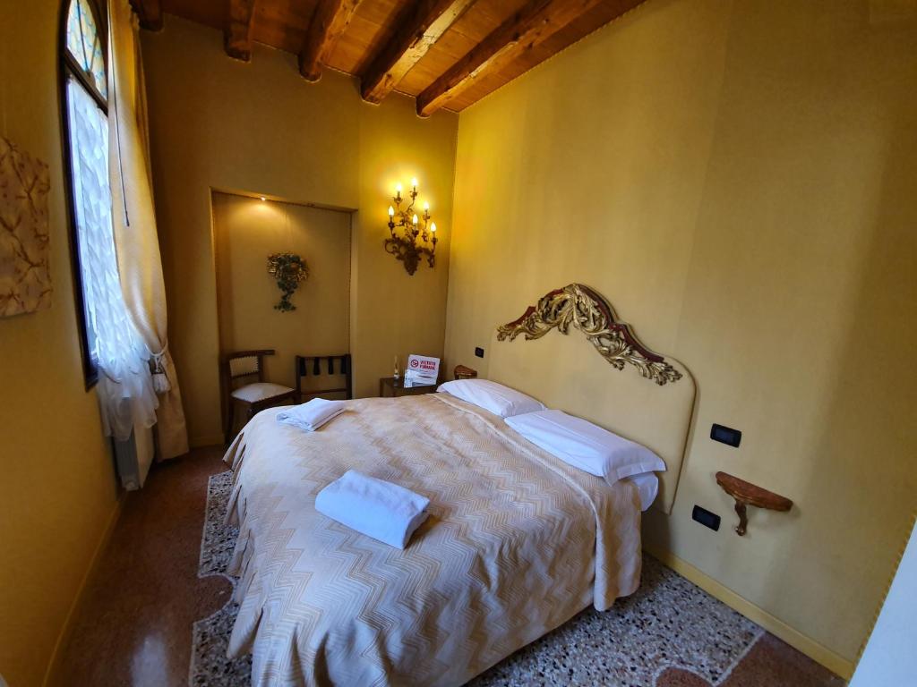 a bedroom with a large bed in a yellow wall at Alloggi Alla Rivetta in Venice