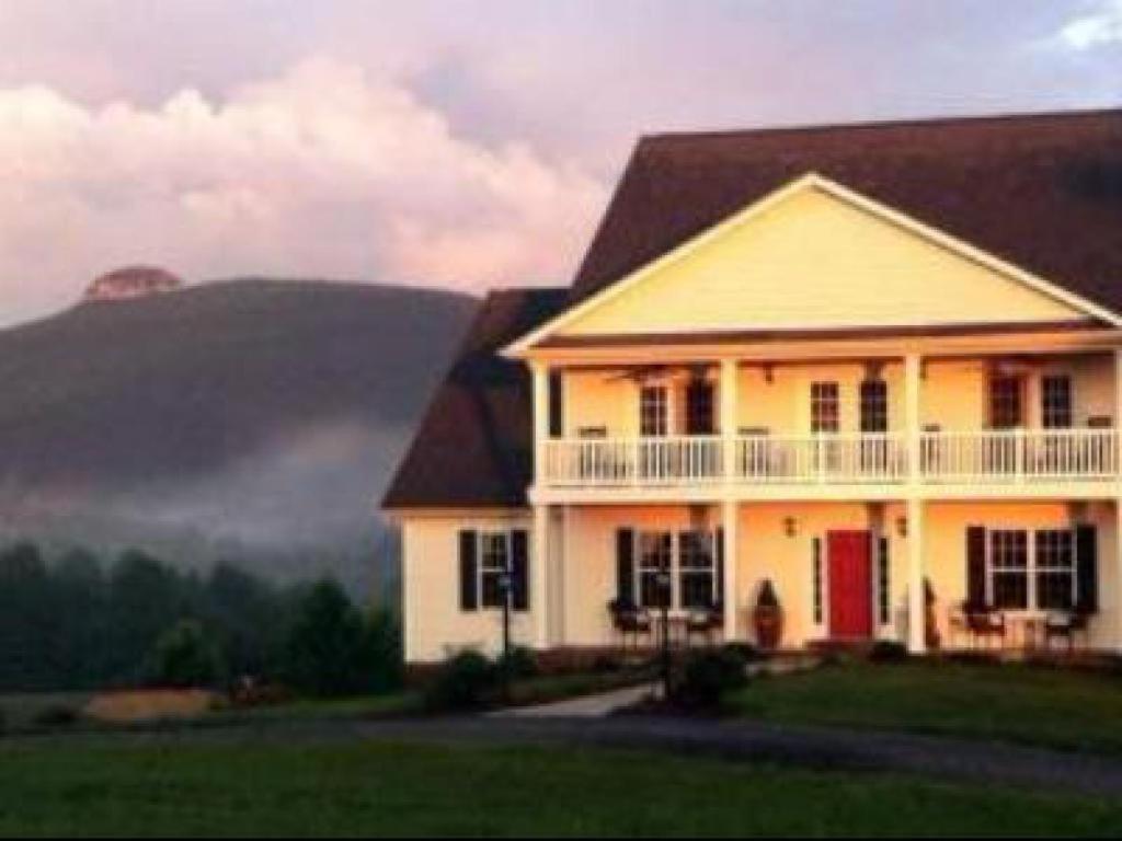 a large house with a mountain in the background at A Mighty Oak B&B in Pilot Mountain