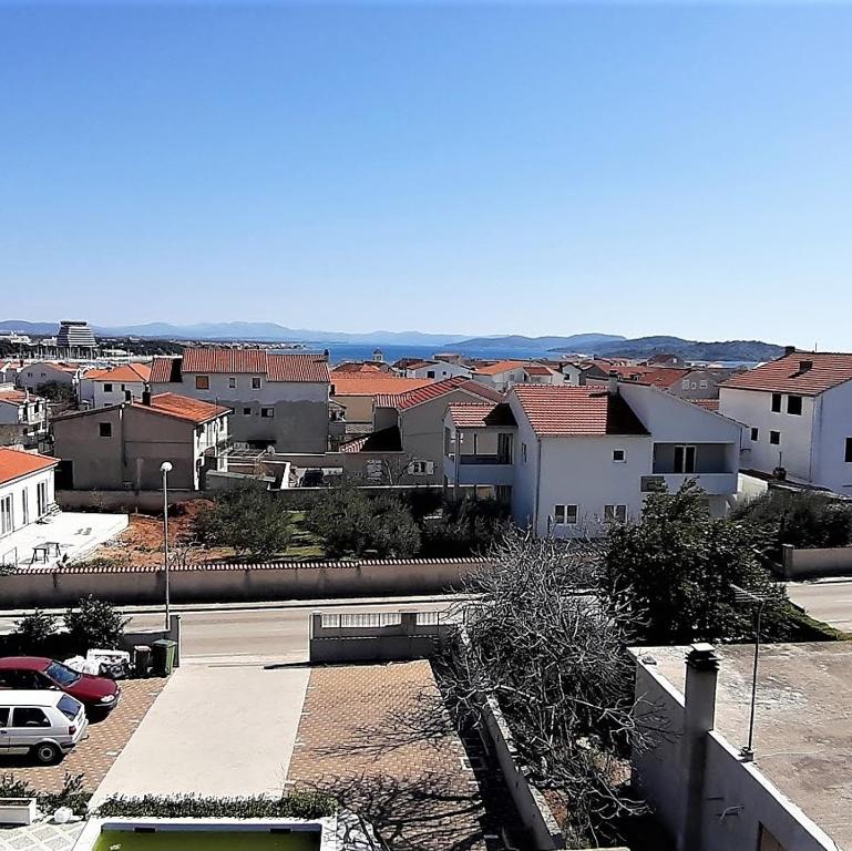 Blick auf eine Stadt mit Häusern und Autos in der Unterkunft Apartments Nika's View in Vodice