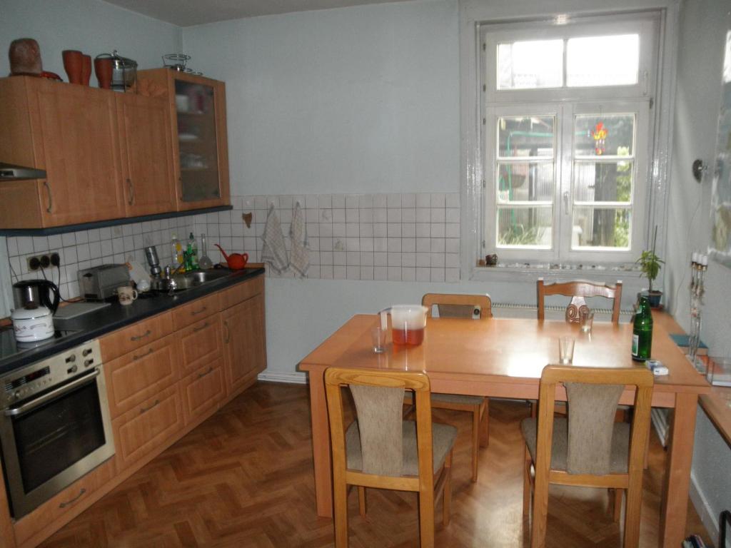 eine Küche mit einem Holztisch sowie einem Tisch und Stühlen in der Unterkunft Altstadthaus in Arnsberg