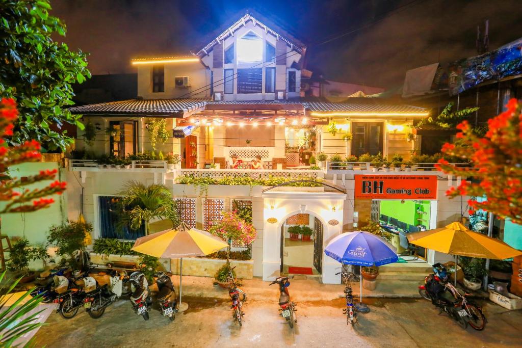 ein Haus mit Fahrrädern, die davor geparkt sind, mit Sonnenschirmen in der Unterkunft Bac Huong House in Tuy Hoa