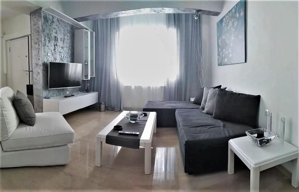 a living room with a couch and a table at Super Nuova - Private Parking in Thessaloniki