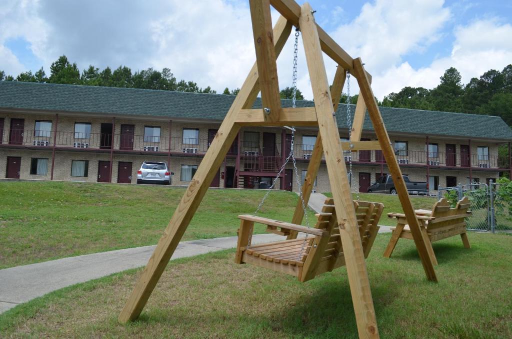 un columpio de madera frente a un edificio en Ouachita Mountain Inn, en Glenwood