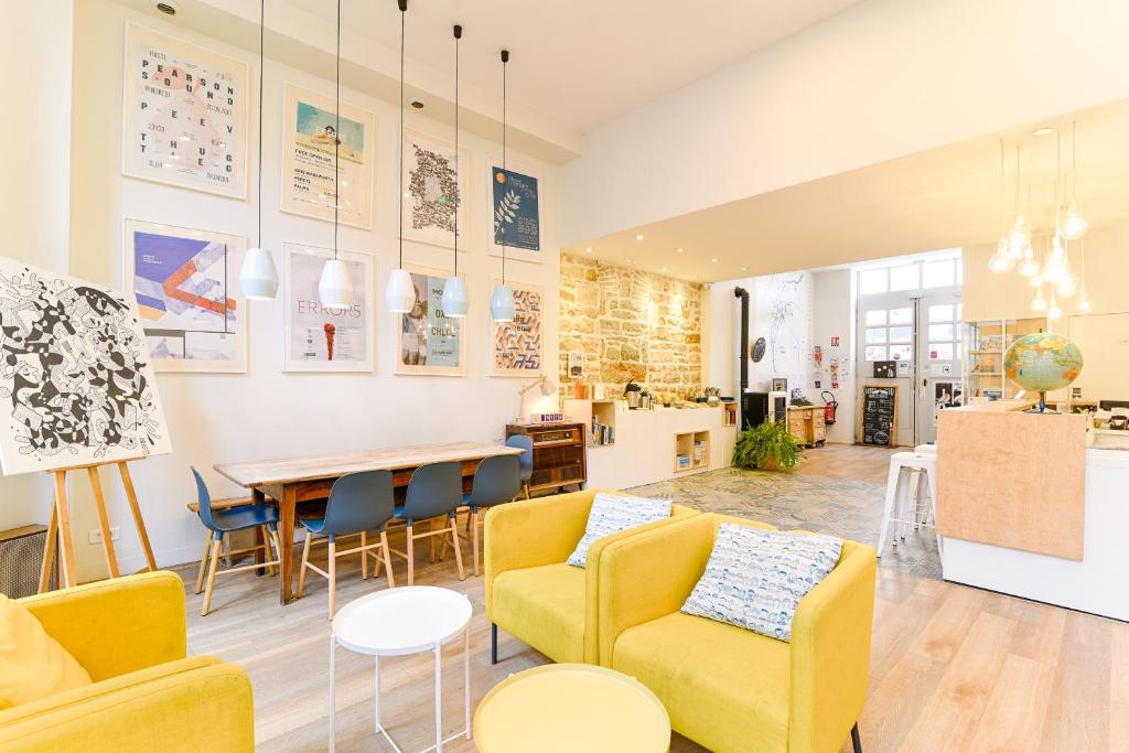 a living room with yellow chairs and a table at SLO Living Hostel in Lyon