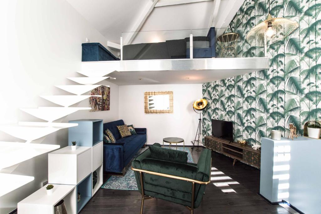 a living room with a staircase and a blue couch at Maison triplex JJ - Ecrin verdoyant au coeur de Lyon in Lyon