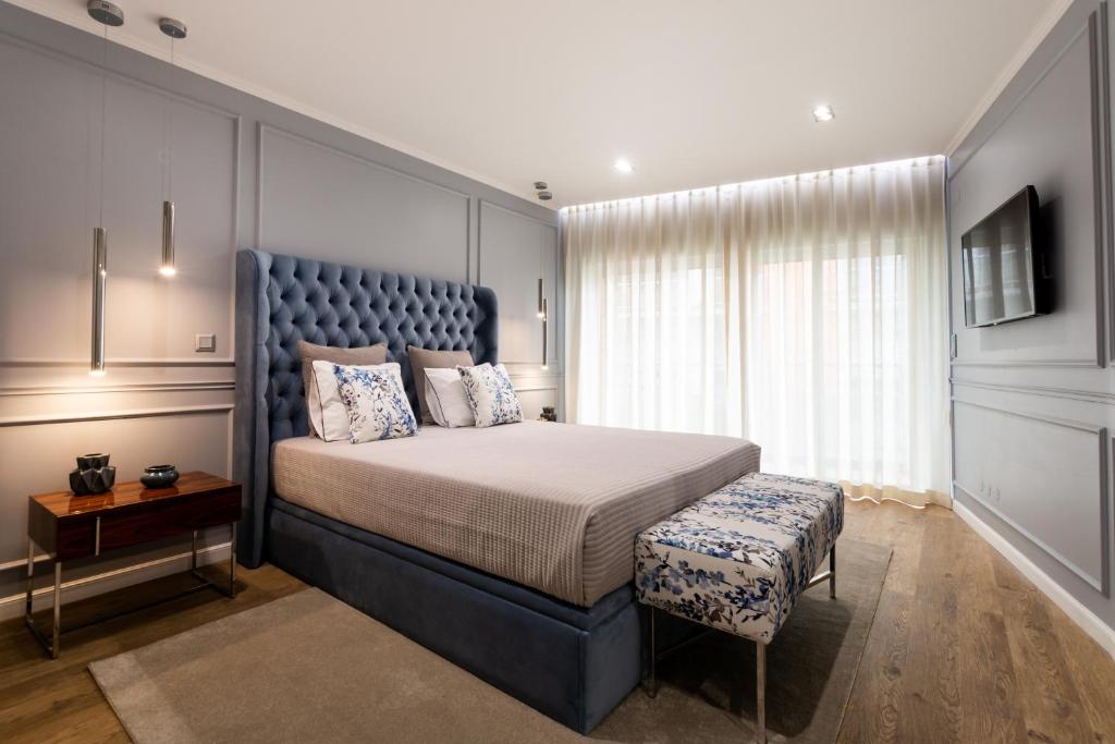 ポンタ・デルガダにあるAzor Central Lodgeのベッドルーム1室(大型ベッド1台、青いヘッドボード付)