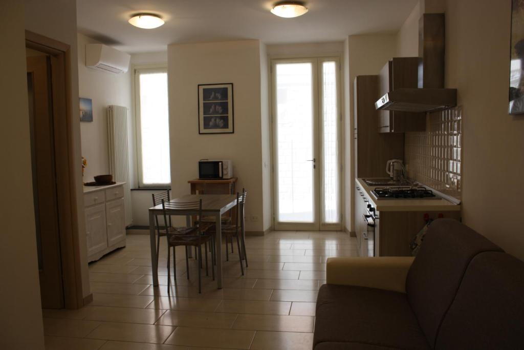 eine Küche und ein Wohnzimmer mit einem Tisch und Stühlen in der Unterkunft Acquamarina in Levanto