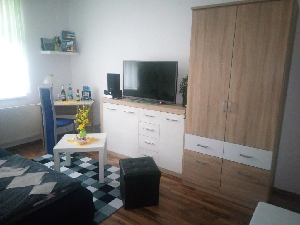 ein Wohnzimmer mit einem TV auf einem Schrank in der Unterkunft Germania in Ilmenau