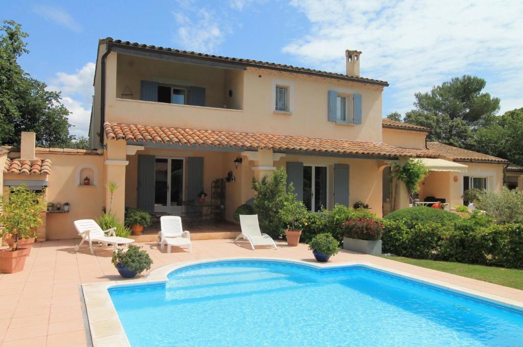 une villa avec une piscine en face d'une maison dans l'établissement Le Bosquet, à Saint-Didier
