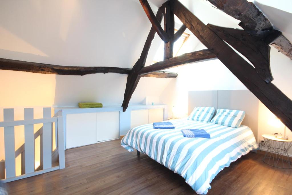 Schlafzimmer mit einem Bett mit blauer und weißer Bettwäsche in der Unterkunft Entre Mer et Golf in Étretat